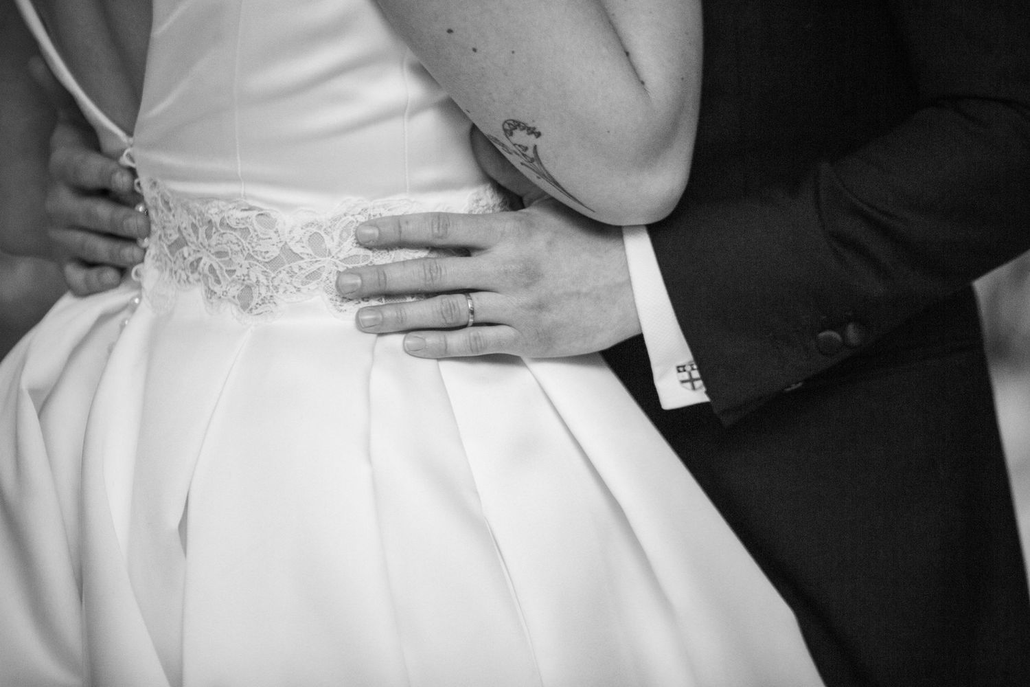 Elegant white wedding dress details shown during a romantic dance moment.
