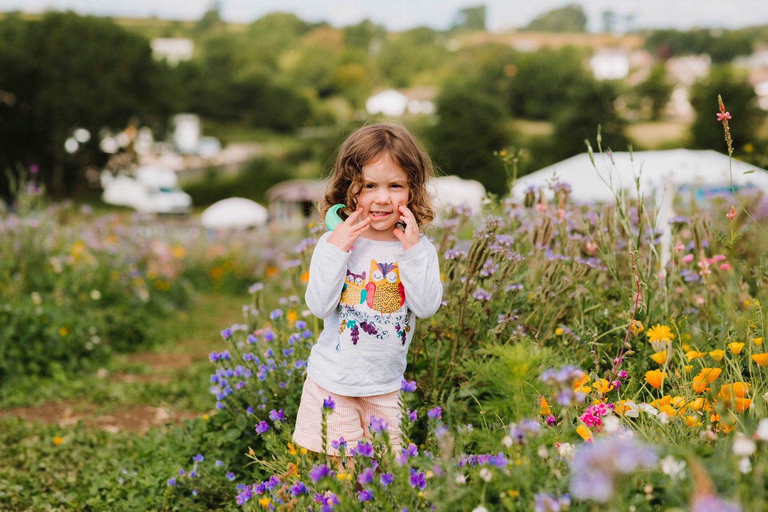 Child exploring through colorful wildflower meadow with purple and yellow blooms.