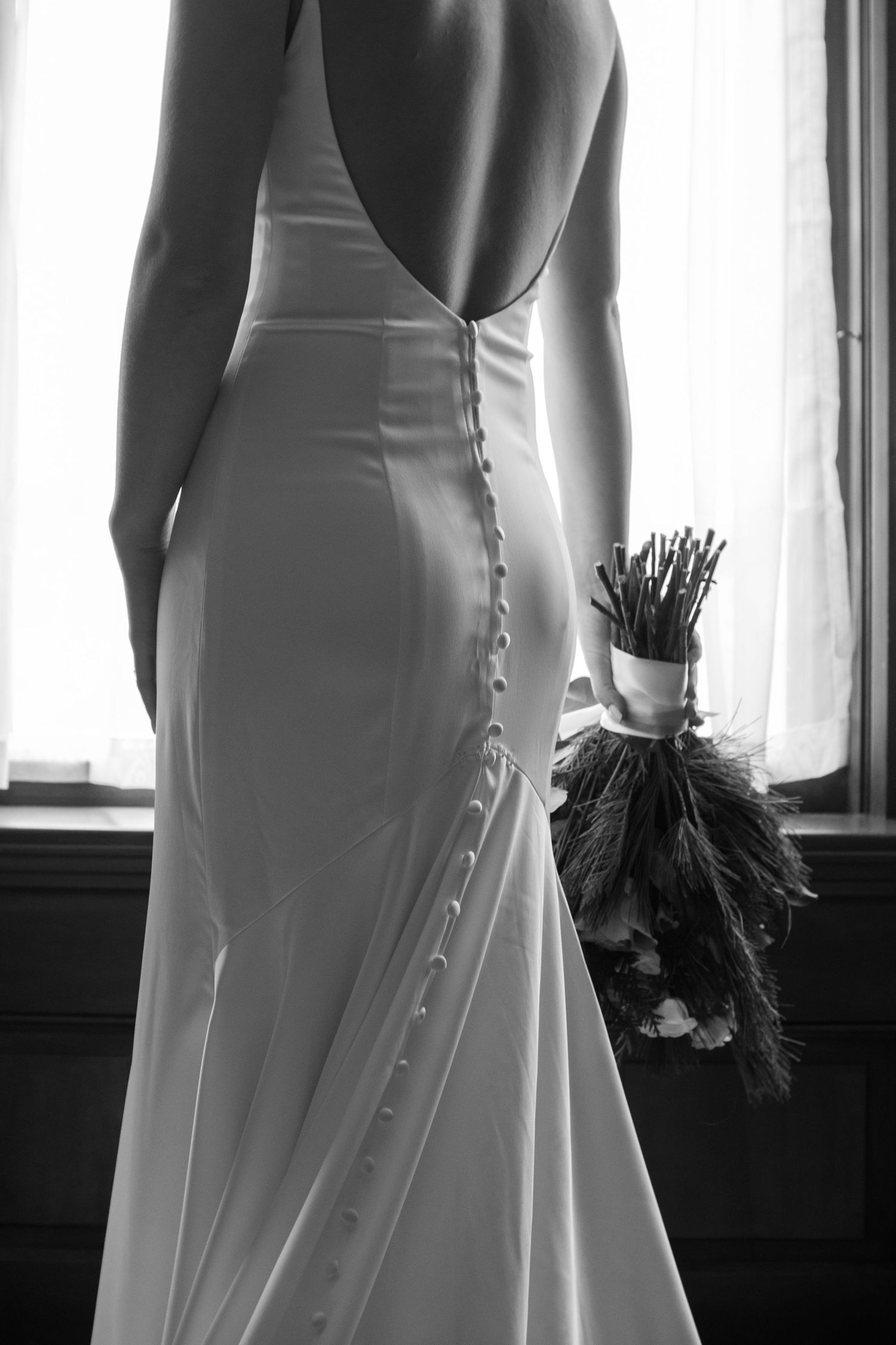 Black and white photo of wedding dress buttons and details from behind.