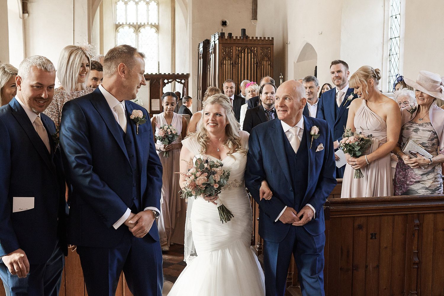 groom looks on as he sees his bride for the first time at the top of the aisle by Faye Amare Photography