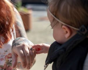 Close-up sequence showing hands with tattoos and emotional expressions during a special moment.