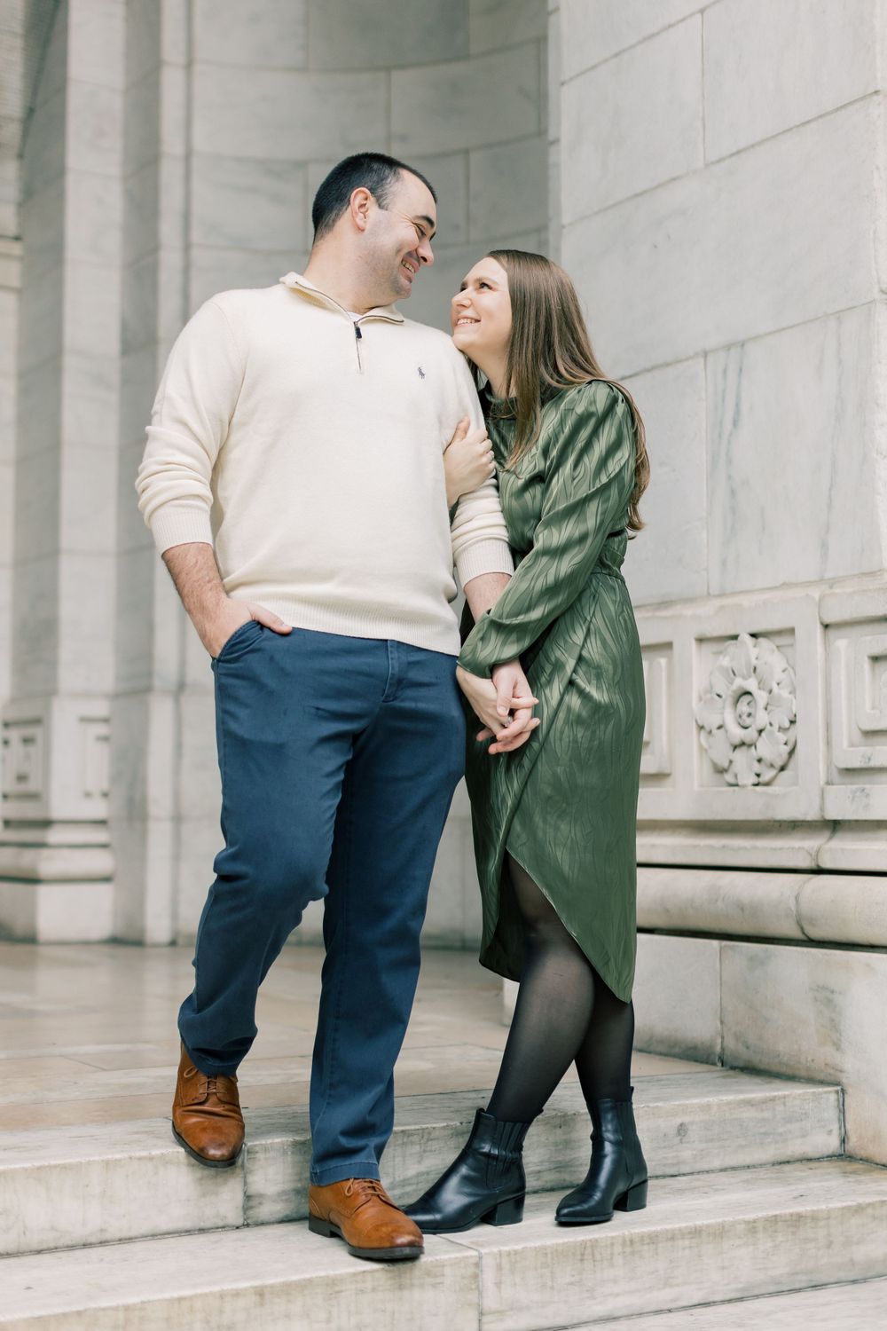 Stylish couple poses on stone steps during engagement photos.