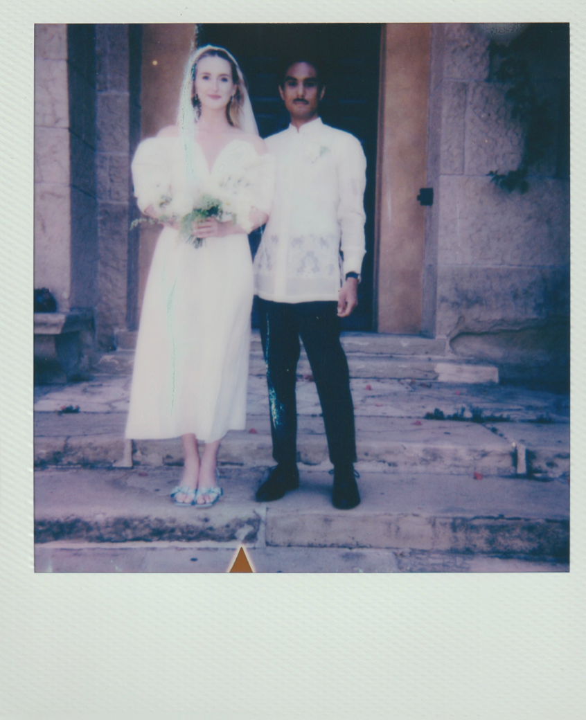 Retro polaroid wedding photo on church steps with Spanish colonial architecture.
