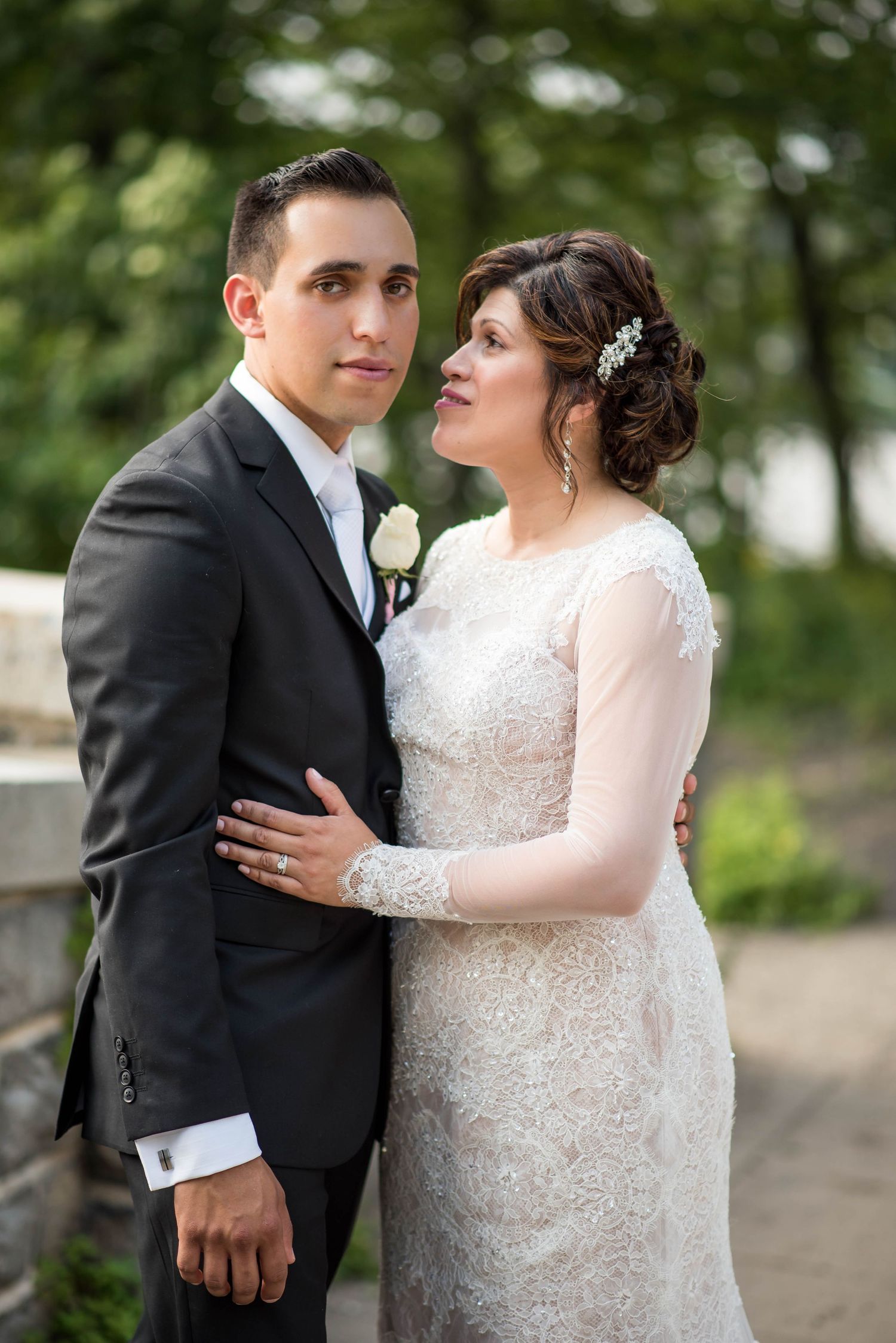 Wedding portrait of couple in traditional formal attire with ornate lace details and classic styling.