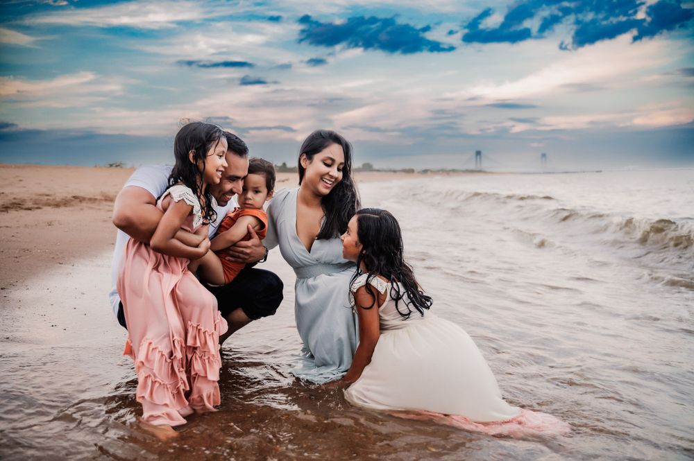 Young family holding each other in the water in South Beach Staten Island
