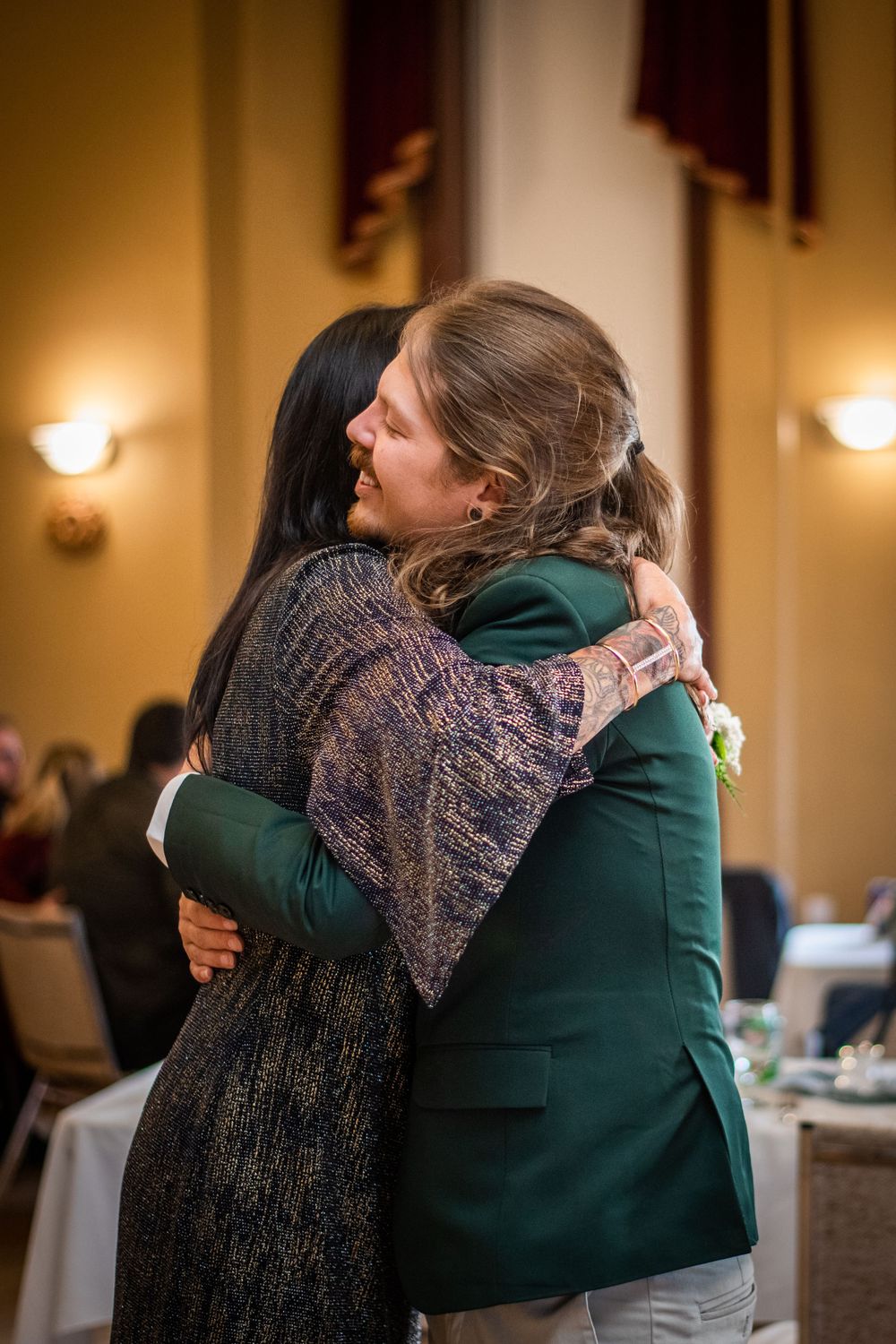 candid groom hugging mother of the groom at acton town hall wedding reception