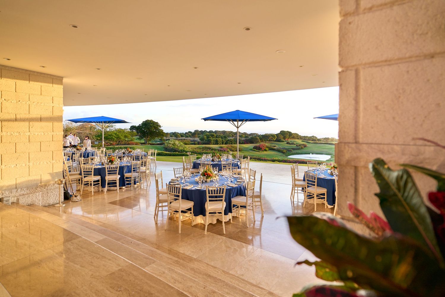 Golf Club restaurant terrace with blue and white dining setup overlooking coastal scenery.