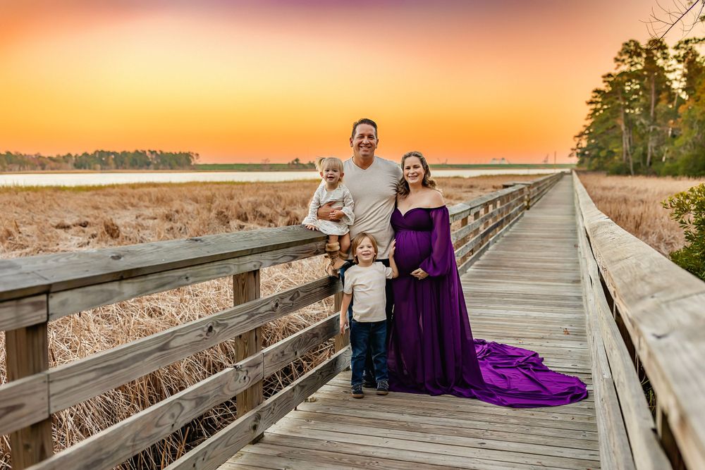 Wooden boardwalk at sunset with purple dress flowing in the golden light.