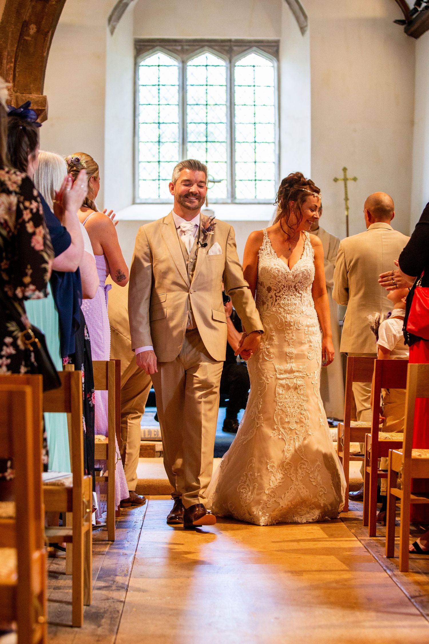 Newlyweds celebrate with joyful dance moves down the church aisle after their ceremony.