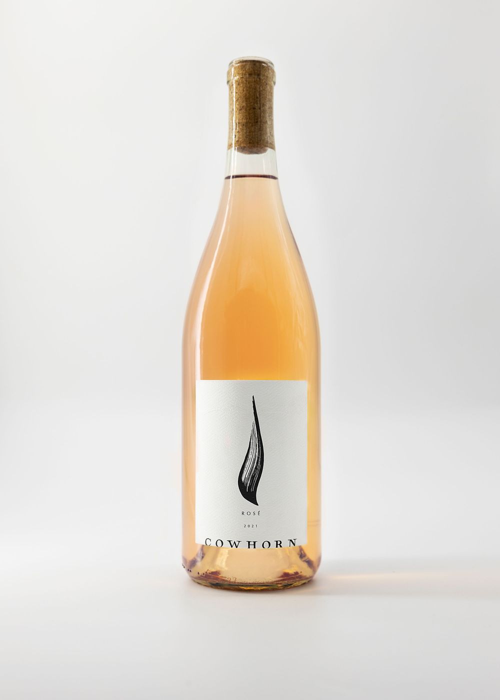 Rose colored wine bottle with black feather logo on white label.