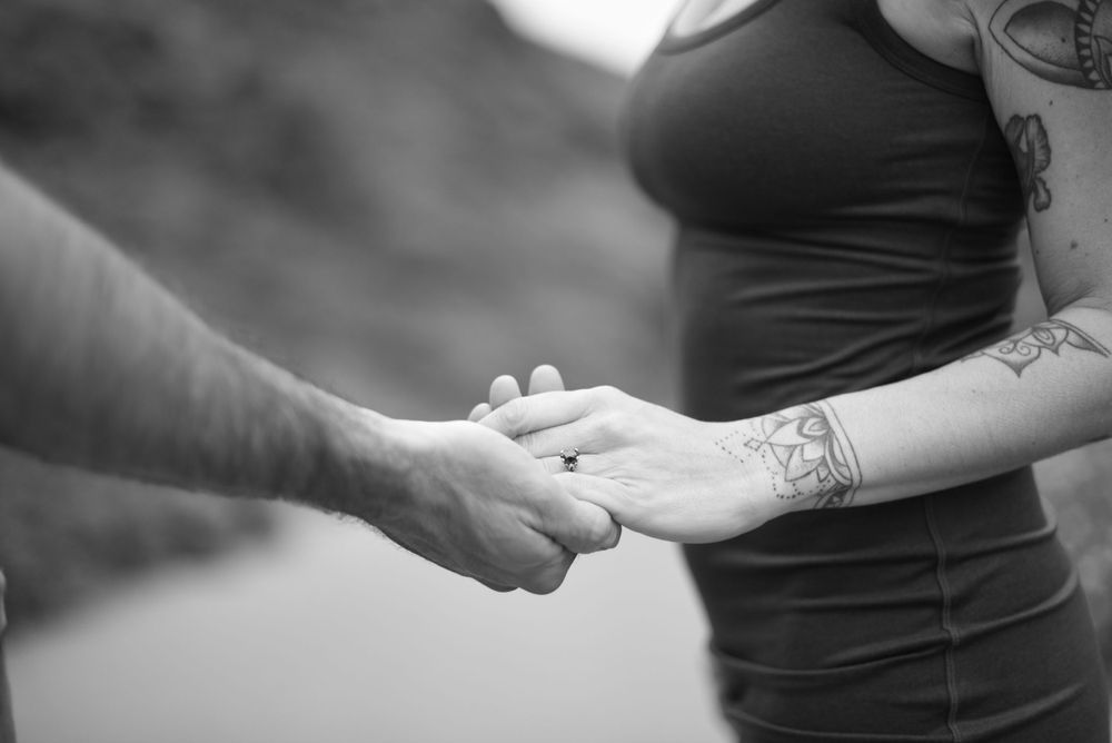Close up of hands coming together in an intimate gesture on a beach path.