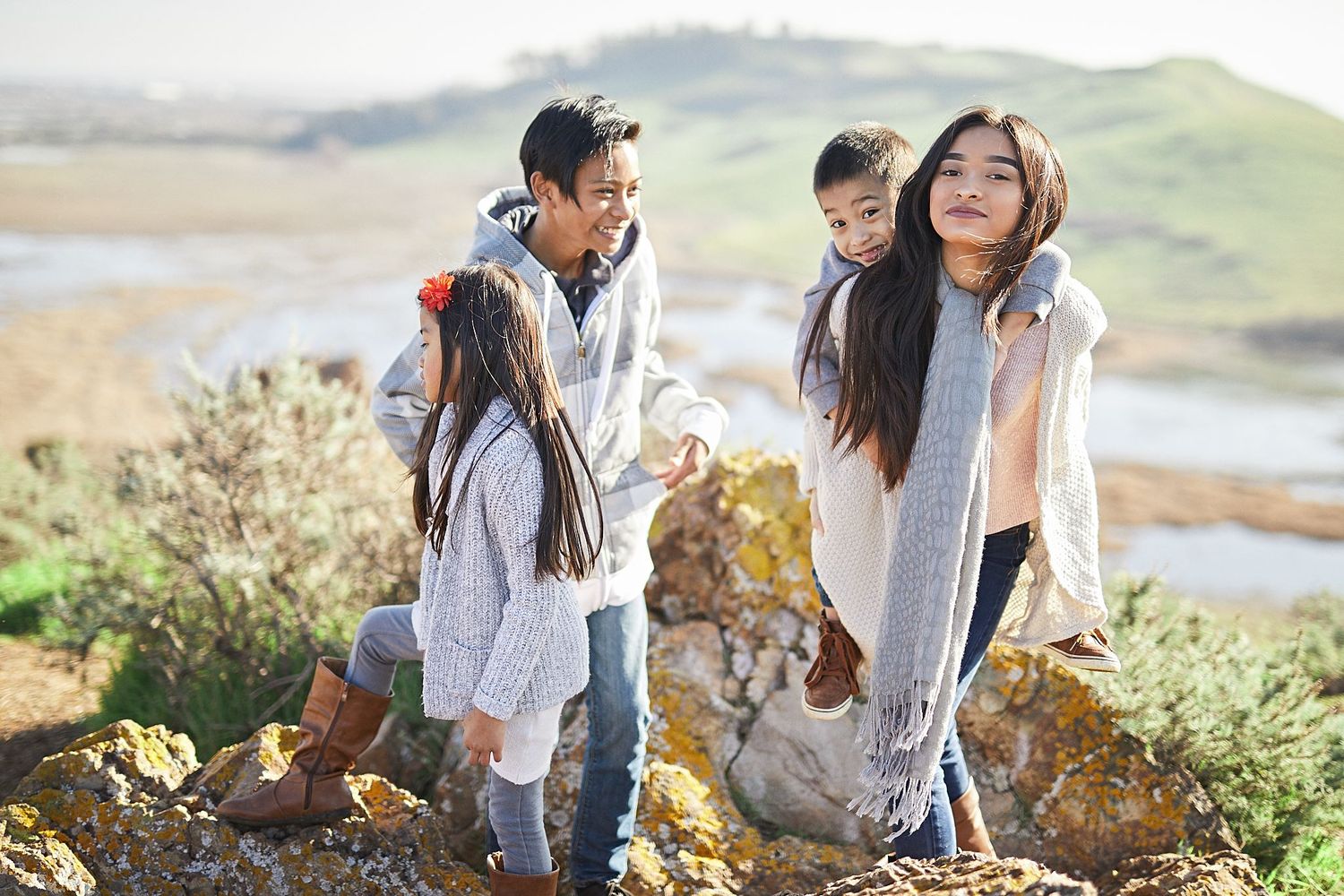 A family explores a scenic coastal hiking trail together on a bright day.