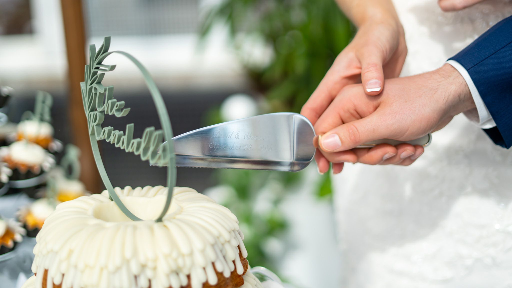 Close-up shots of wedding cake being cut during reception celebration.