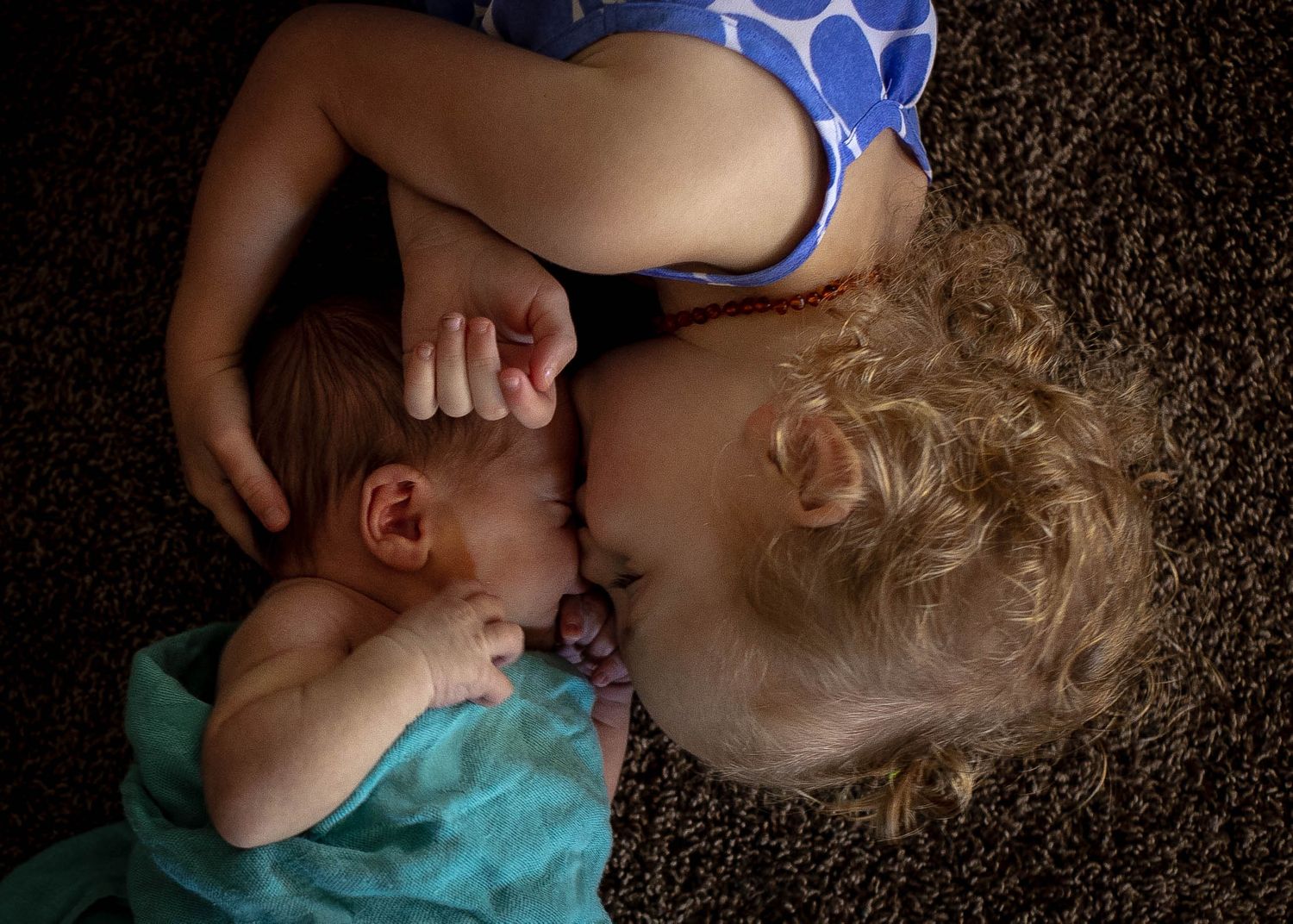 Big sister giving her baby brother a kiss and some snuggles in Sioux City, IA.