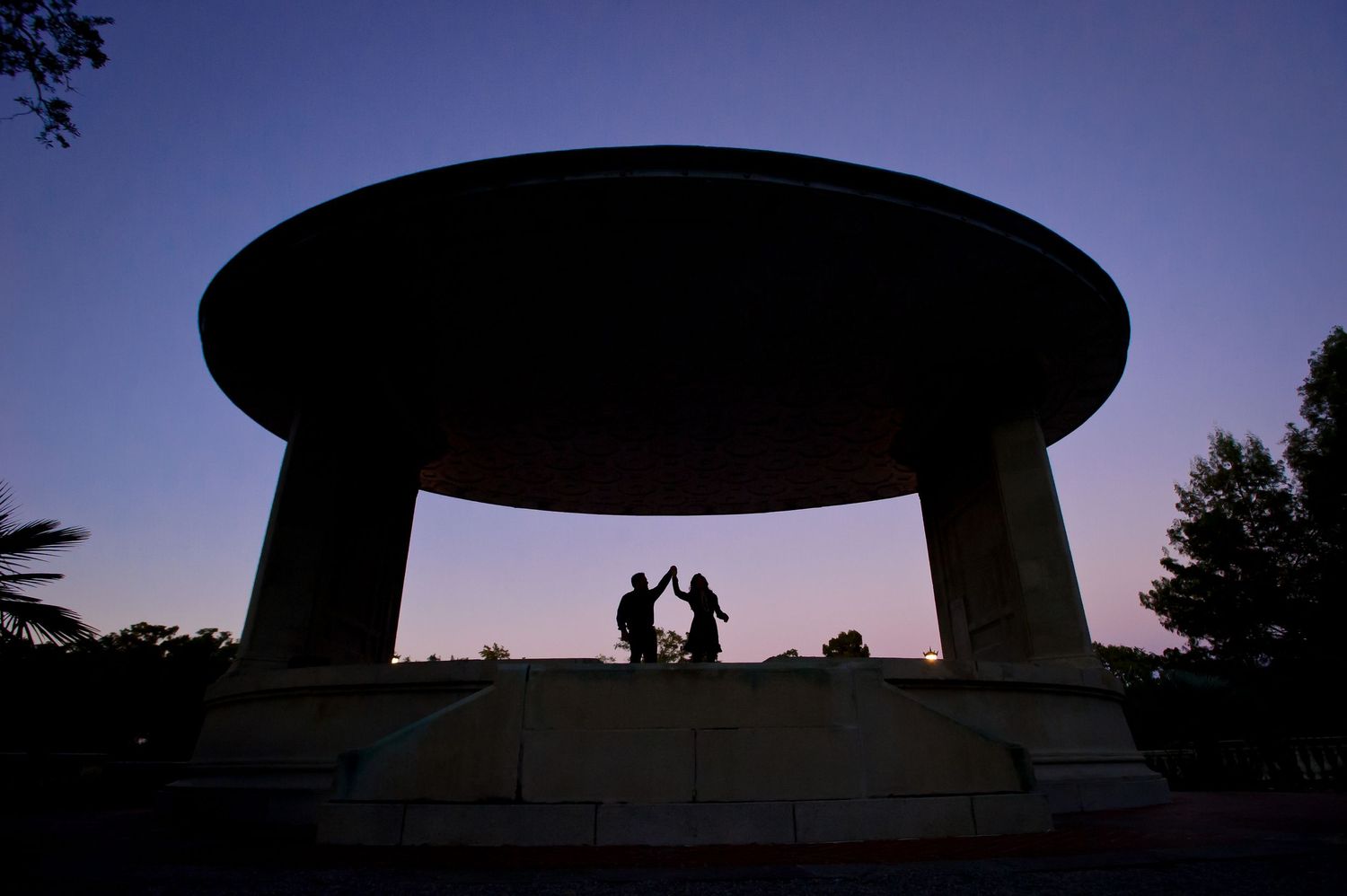 Silhouette of outdoor wedding venue against deep blue twilight sky.
