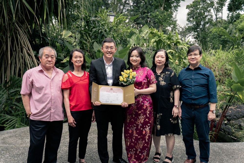 Group photo of family members celebrating a special occasion in a garden setting.