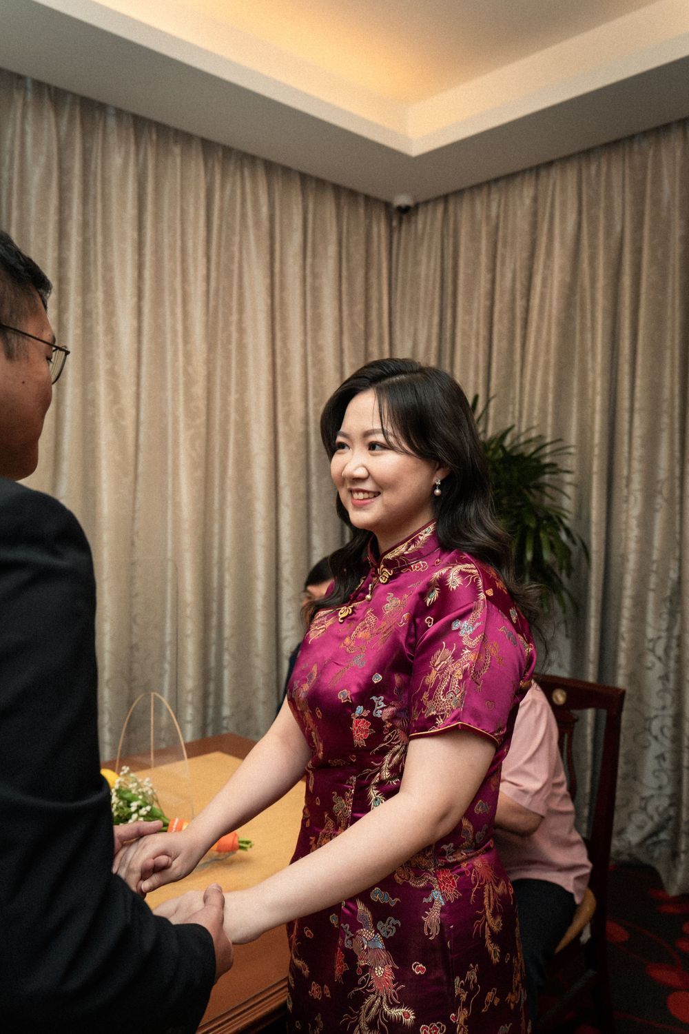Traditional celebration scene with participants in formal attire indoors.
