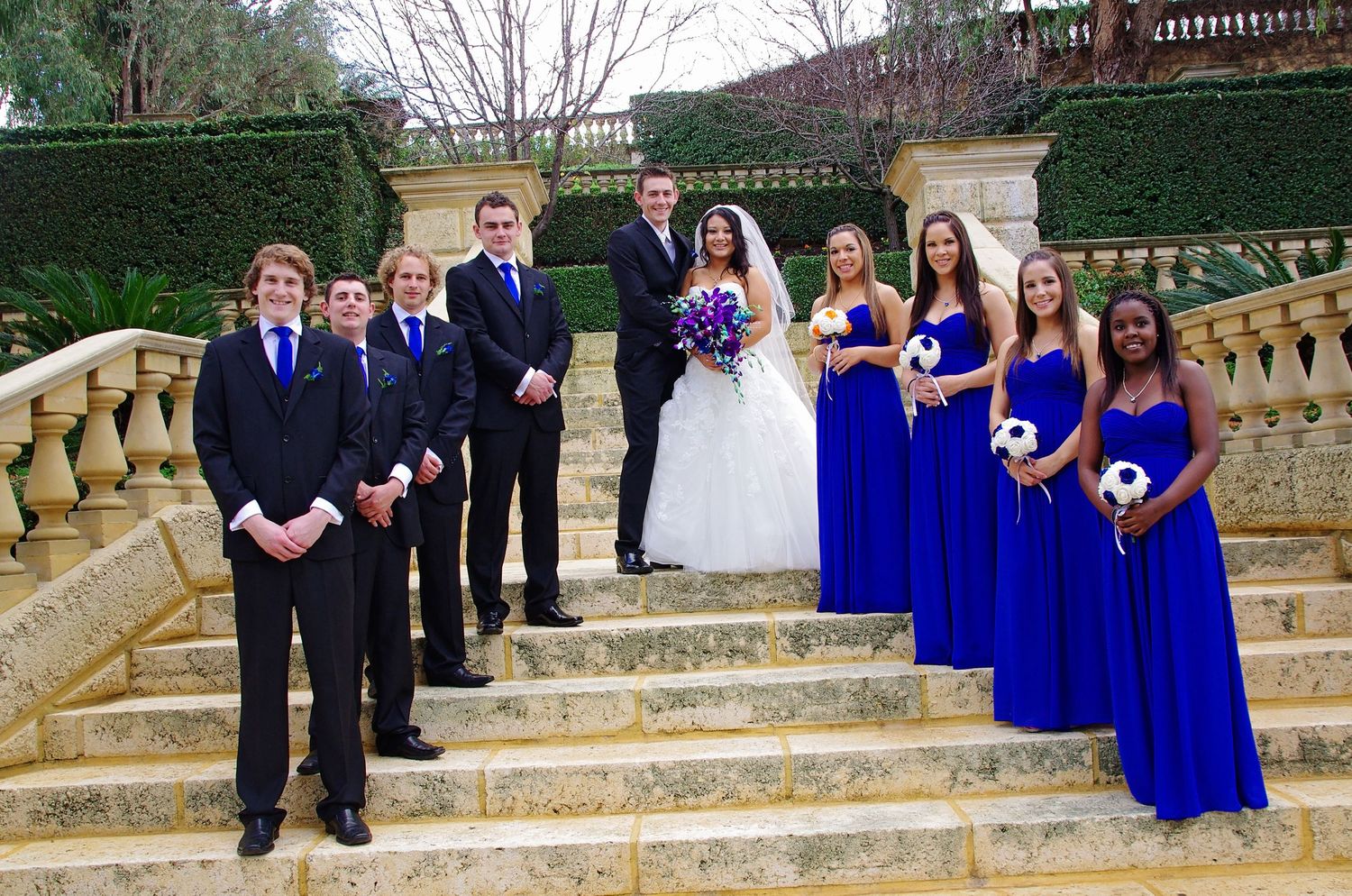 bridal party posing on steps and looking at camera with bride and groom
