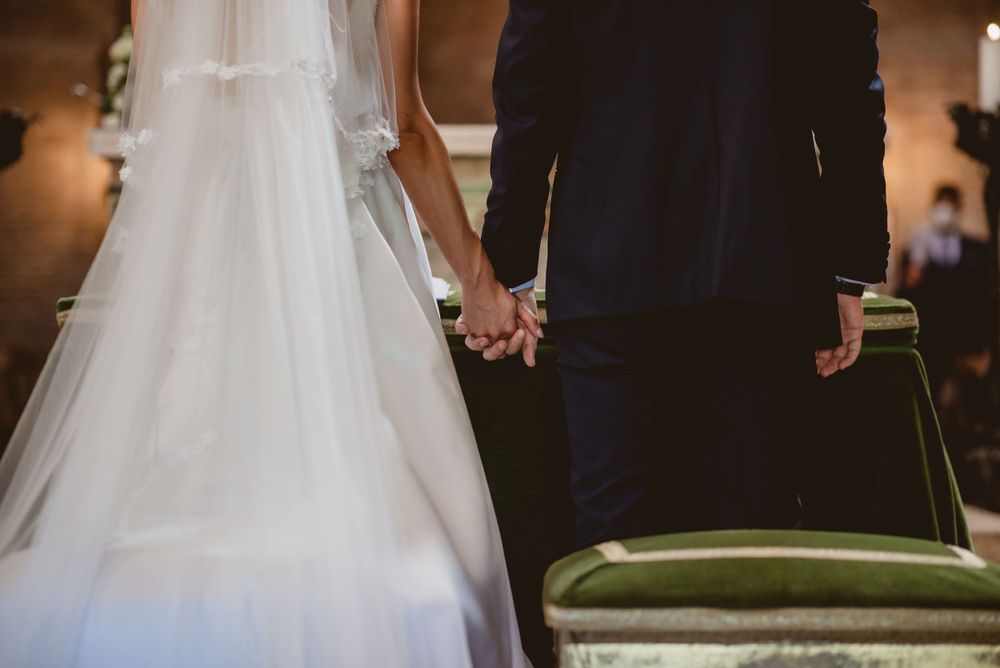 A romantic wedding scene with flowing white dress against dark interior decor.