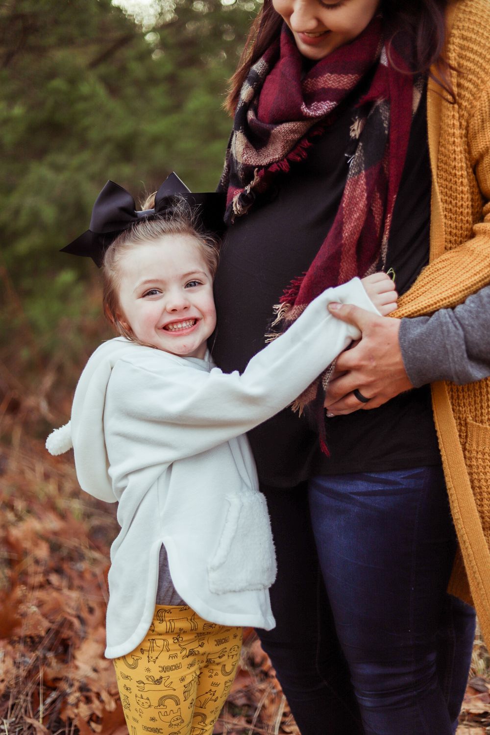 Candid family moments captured of toddler in white sweater playing outdoors.