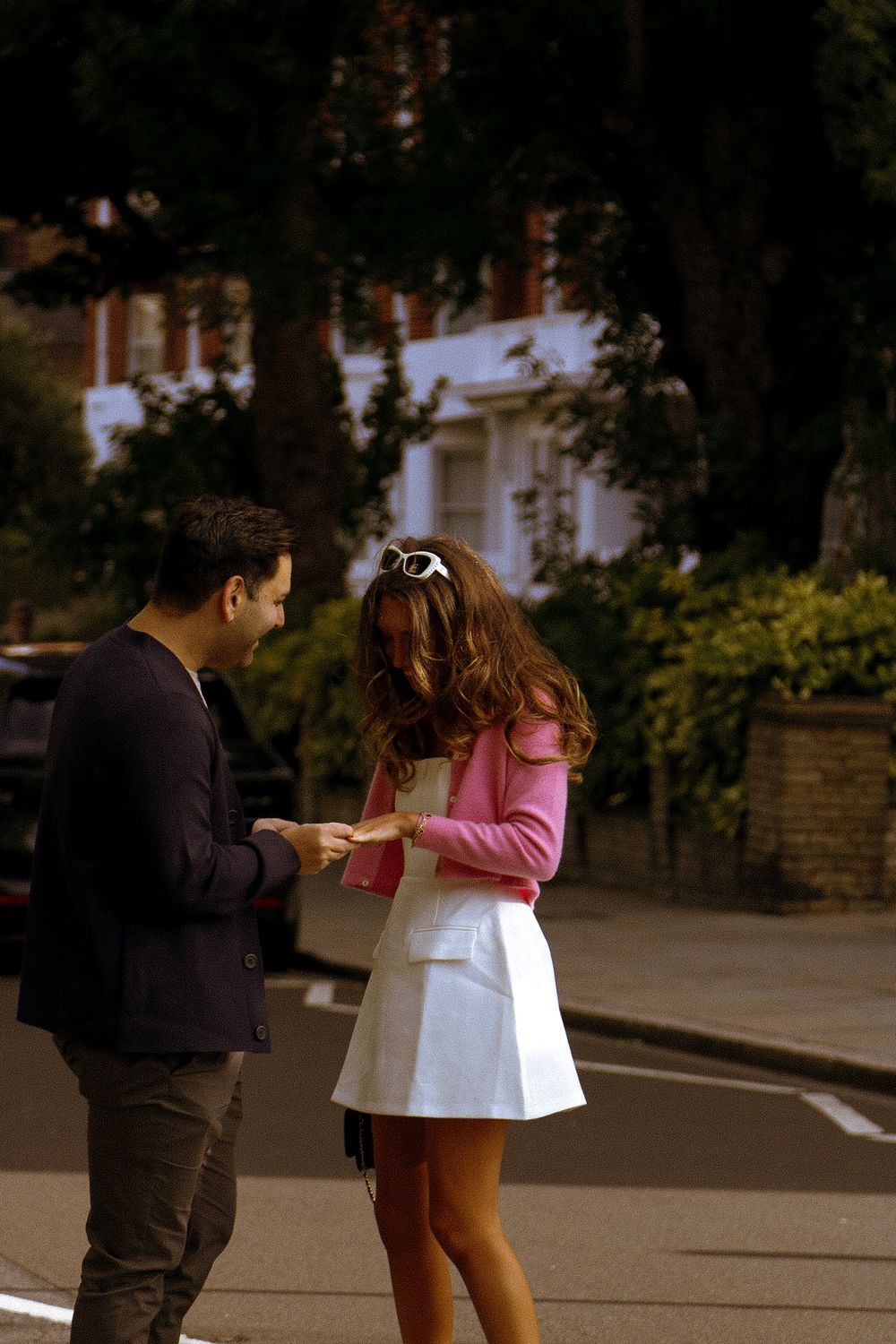 A couple sharing an intimate moment on a London street during a proposal.
