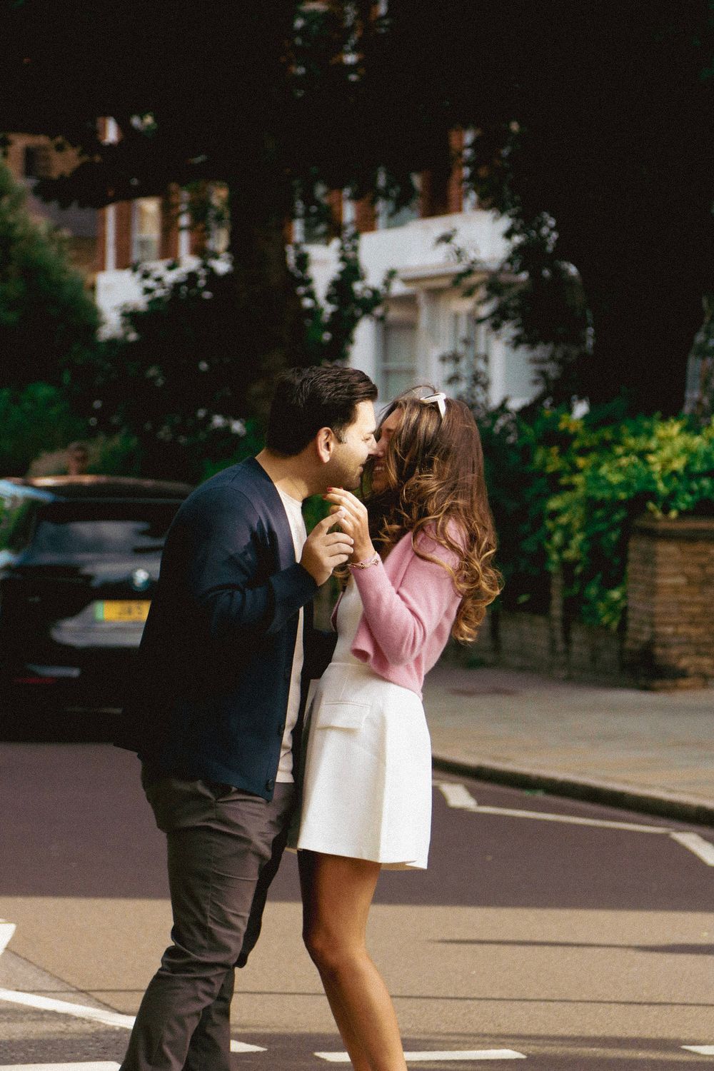 A couple embracing with excitement after a proposal on a London street crossing.