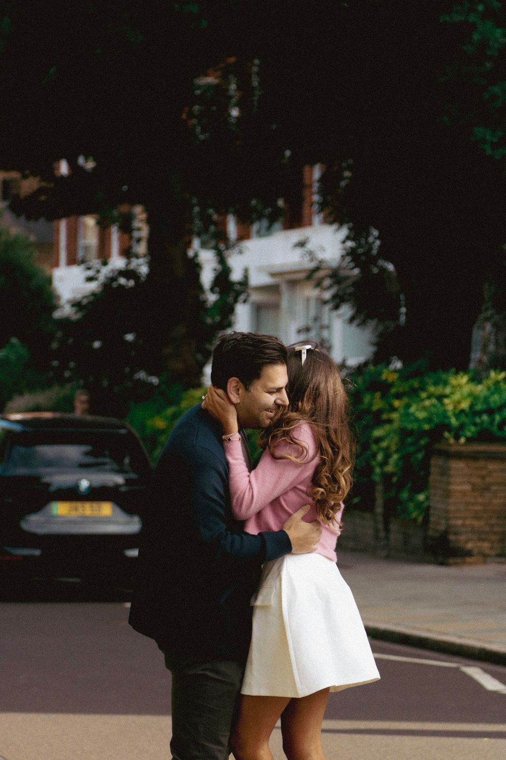 A couple sharing their first kiss after a proposal on a London street.