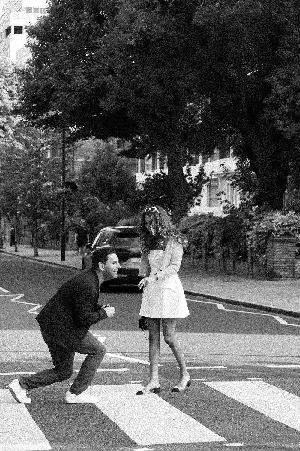 A black and white capture of a proposal moment on a London street crossing.