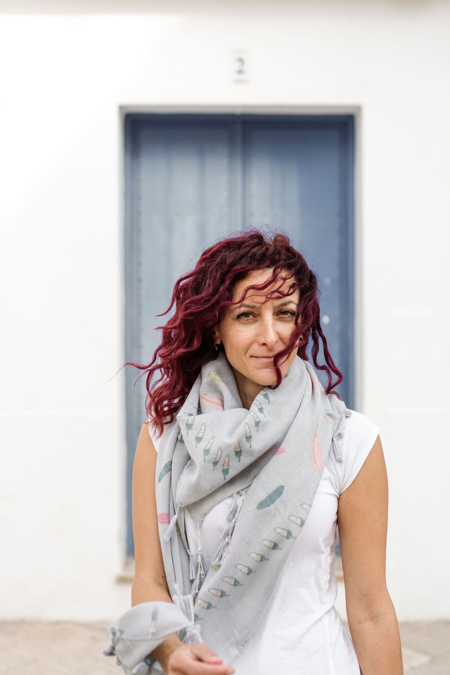 Smiling woman with curly red hair blowing in the wind Rosie Randisi