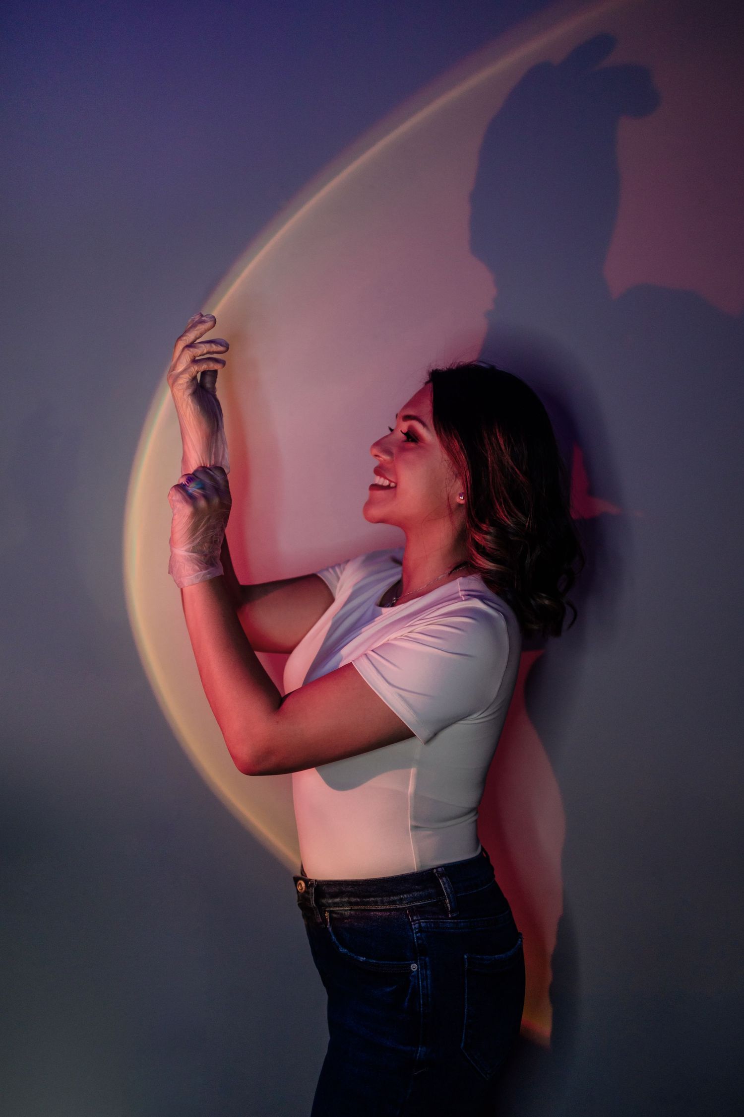 An artistic portrait with projected crescent moon light creating dramatic shadows.