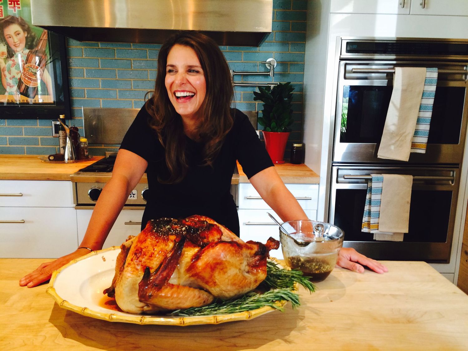 A beautifully roasted turkey presented on a large platter in a modern kitchen setting.