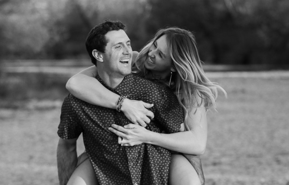 Romantic black and white photo series showing an intimate embrace between a couple in a field.