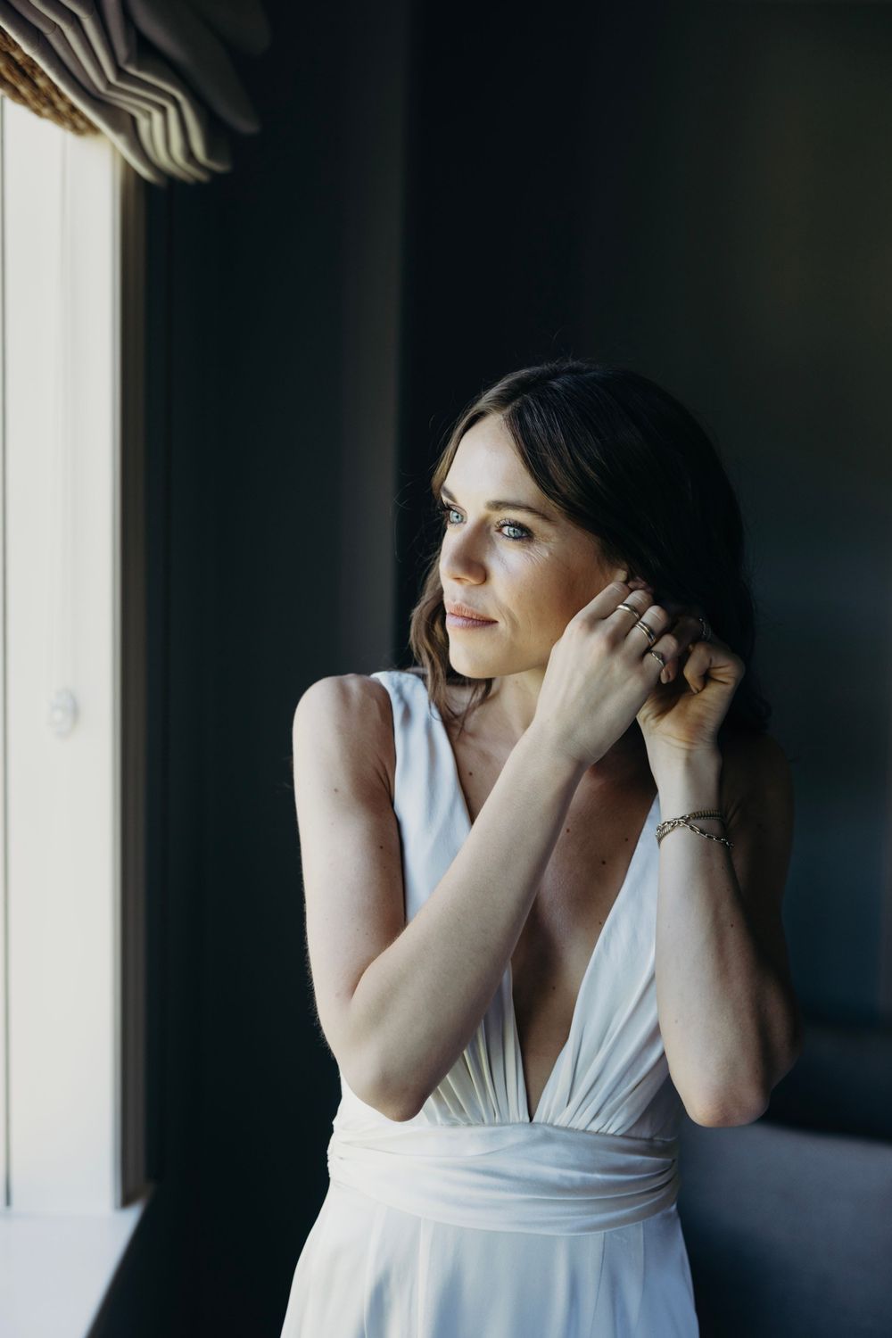 Candid moments captured by window light in an elegant setting.