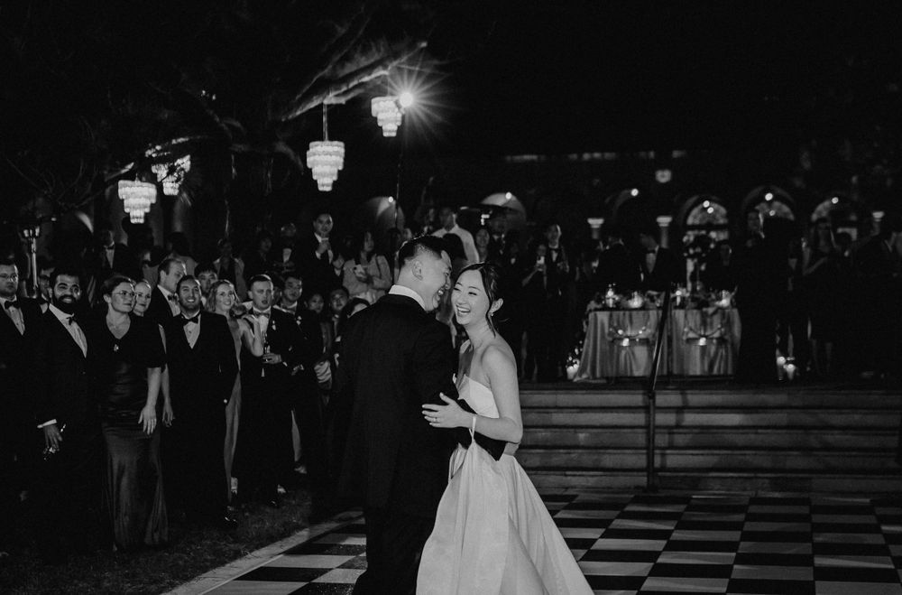 Black and white of a bride smiling during her first dance at a reception at Ringling Museum Courtyard in Sarasota.