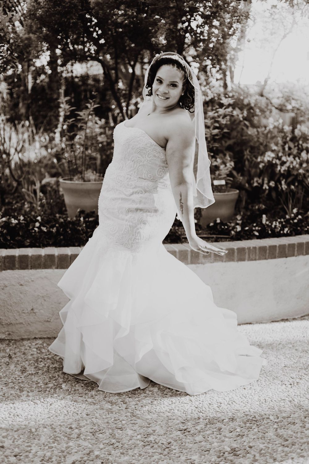 Black and white photos of a bride in a flowing white wedding gown outdoors.