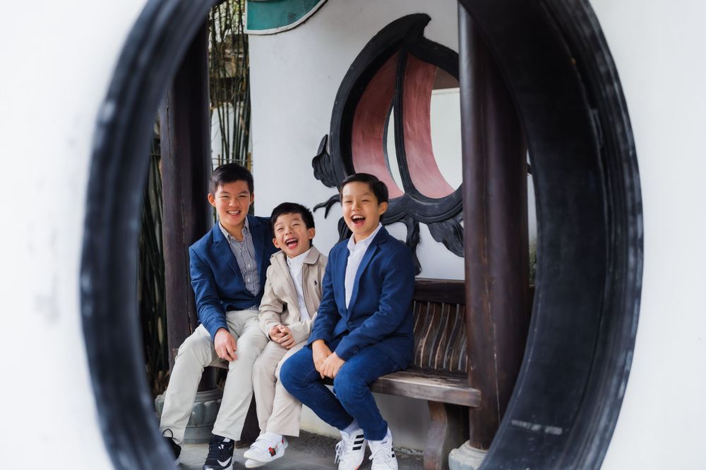 Three people sitting on bench viewed through circular architectural detail.