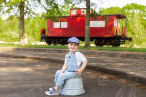 three year old boy, train conductor, train birthday photoshoot, red caboose, train whistle