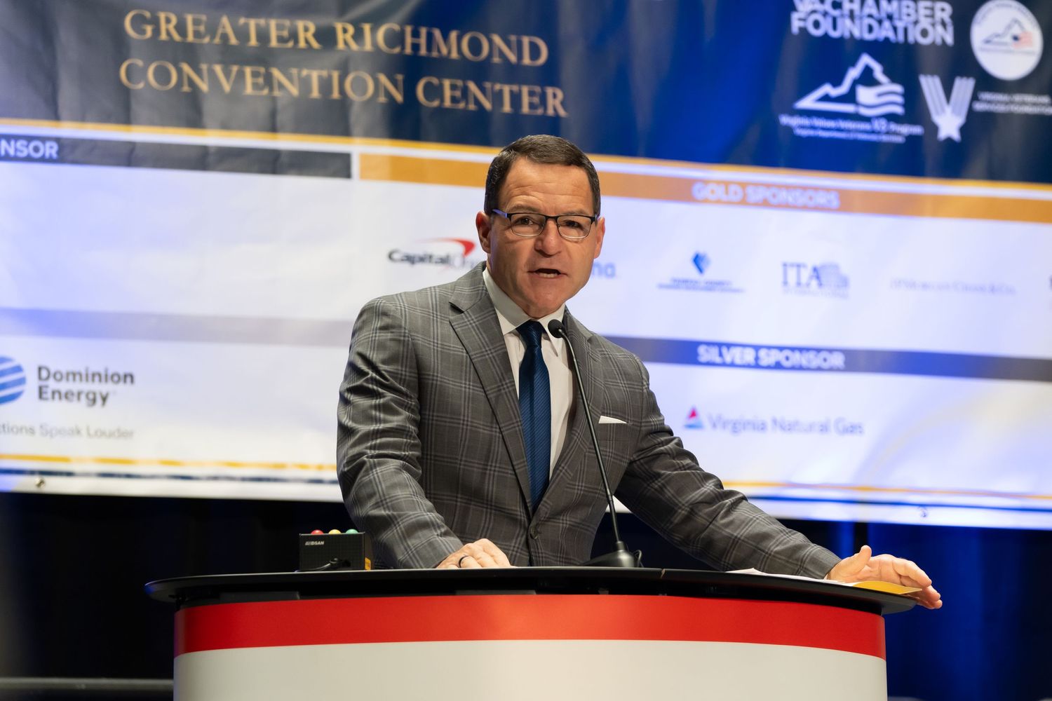 Formal corporate award ceremony, with elegantly dressed attendees and a stage set for speeches and accolades