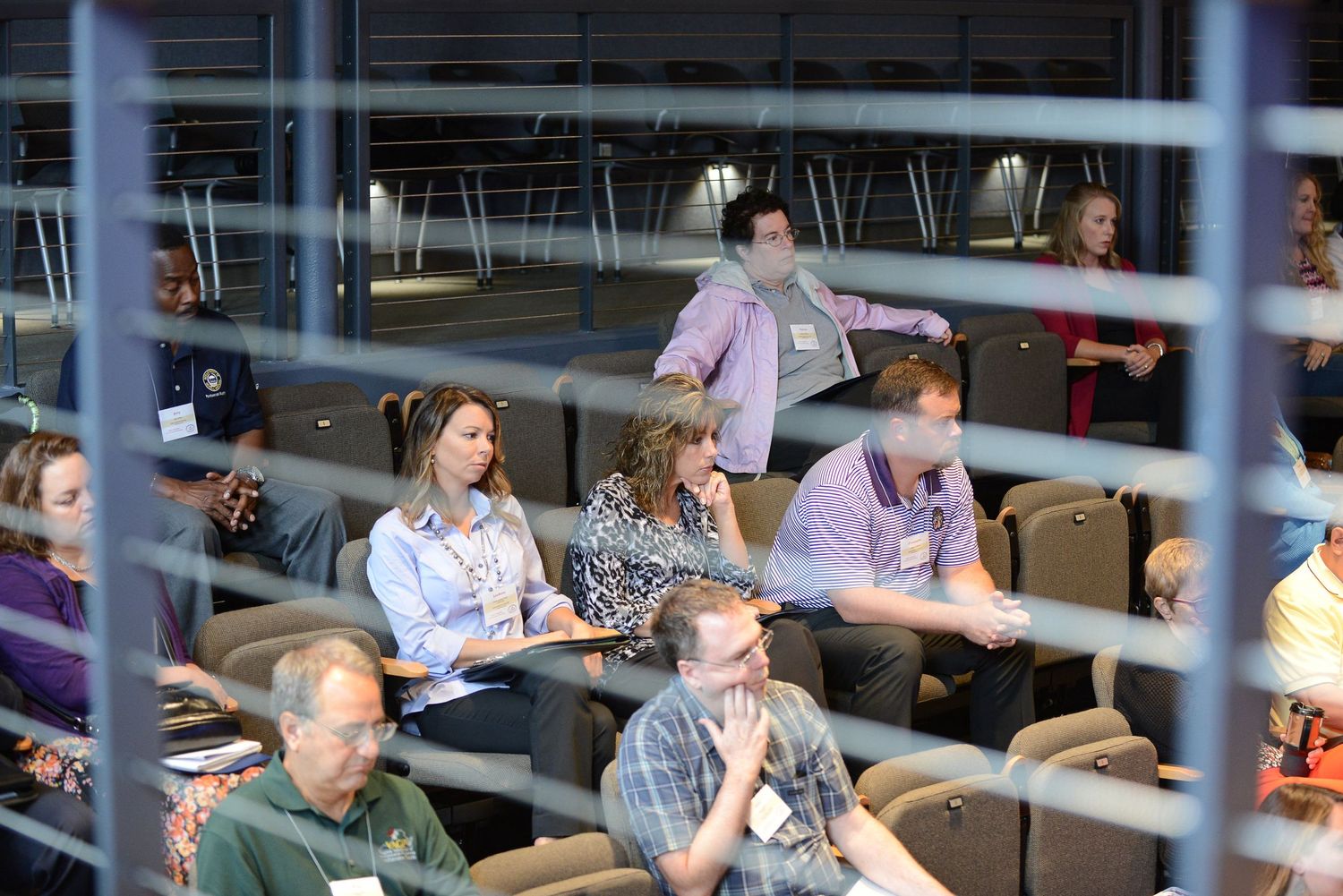 Concentrated professionals at a business event, riveted by a speaker's address