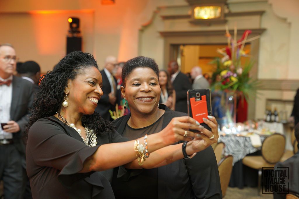 Professional females in business attire snapping a group selfie