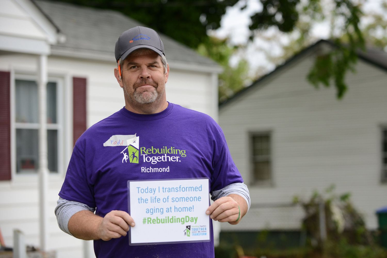 Outdoor corporate team-building event, featuring groups participating in fun, collaborative home repairs