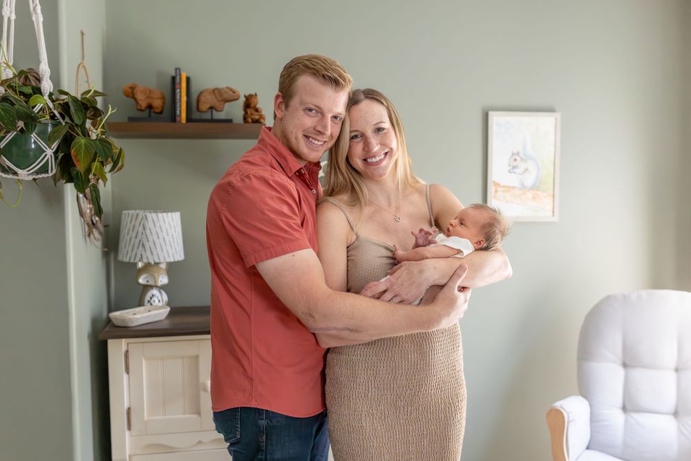 A couple holds their newborn son in his nursery in their Clayton, NC Newborn photoshoot.