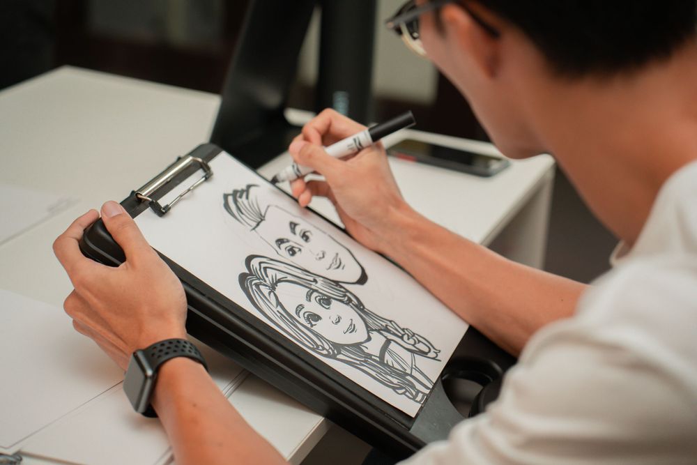 Someone drawing detailed sketches in a notebook with a pen.