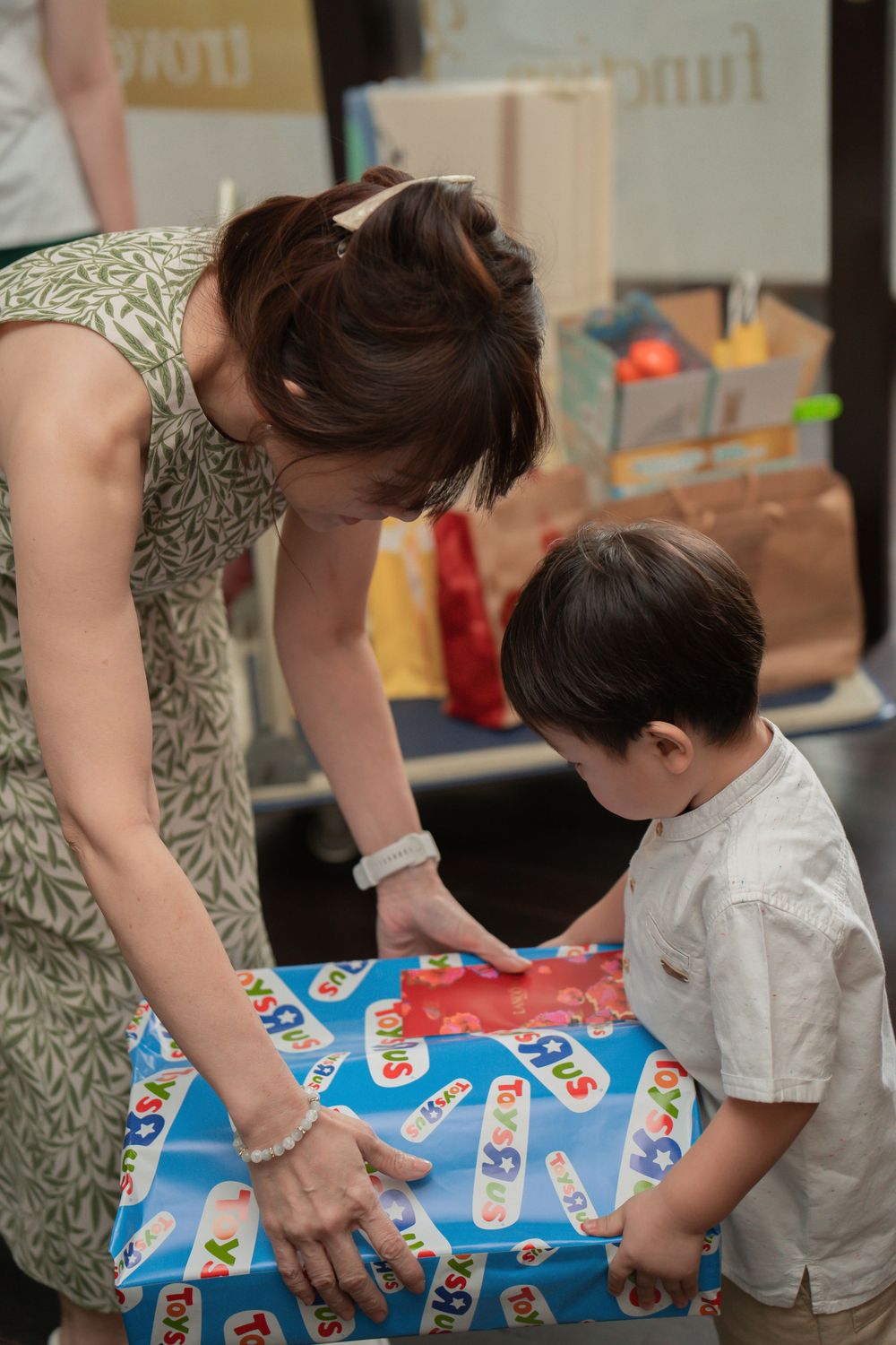 A child and adult playing with a colorful board game on a table.