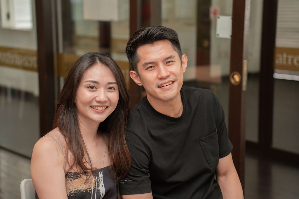 A couple smiling together in a casual indoor setting.