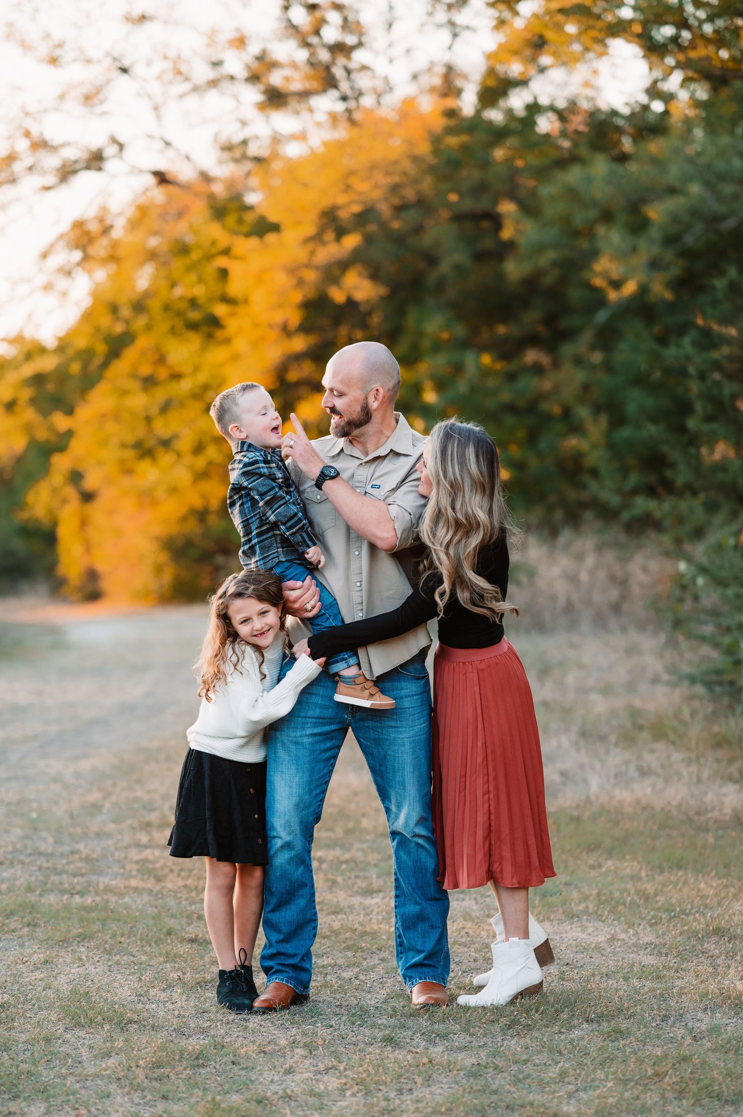 Family of 4 interact candidly for their dallas area outdoor sunrise fall family portrait session in richardson