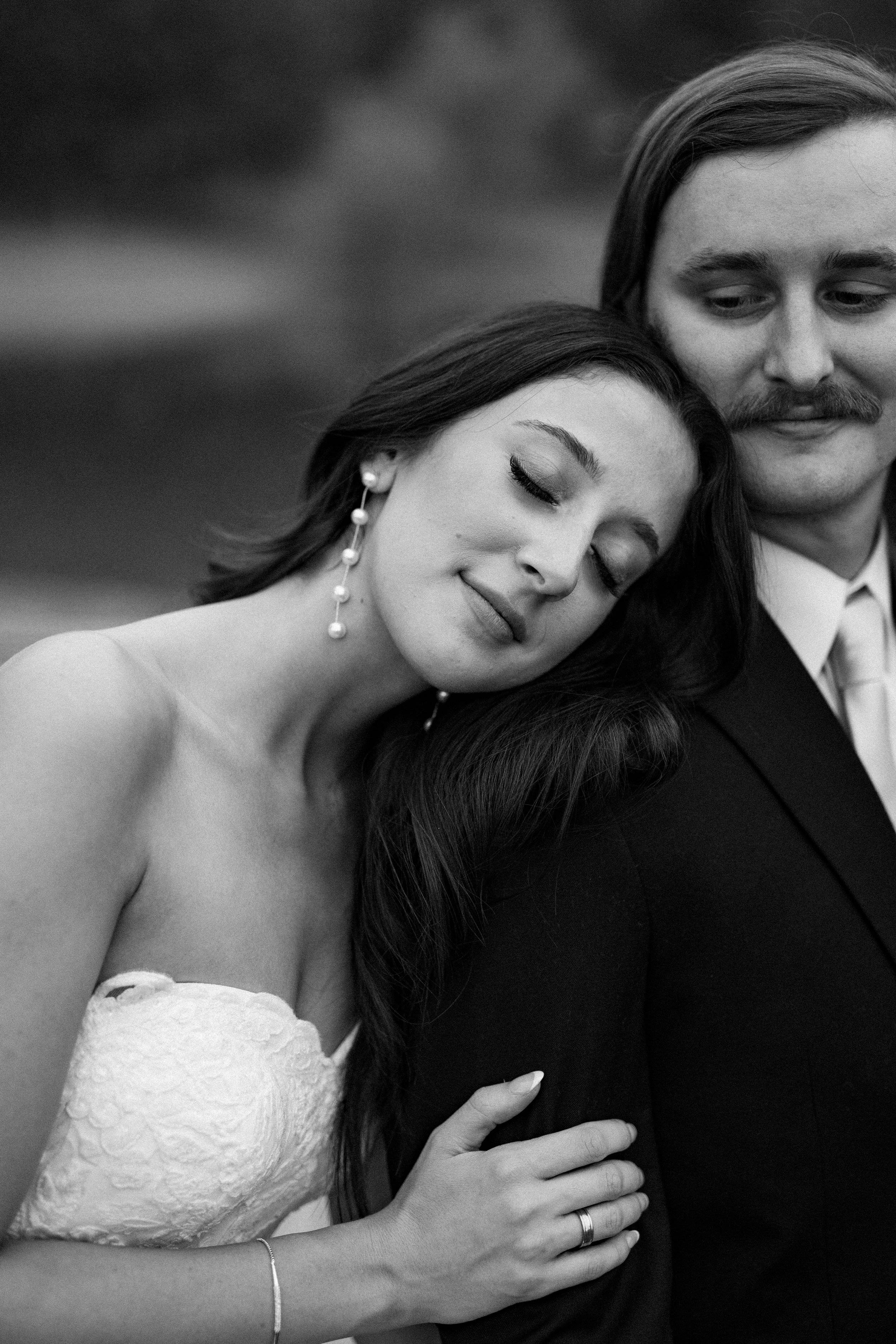 Intimate black and white portrait of wedding couple sharing romantic moment.