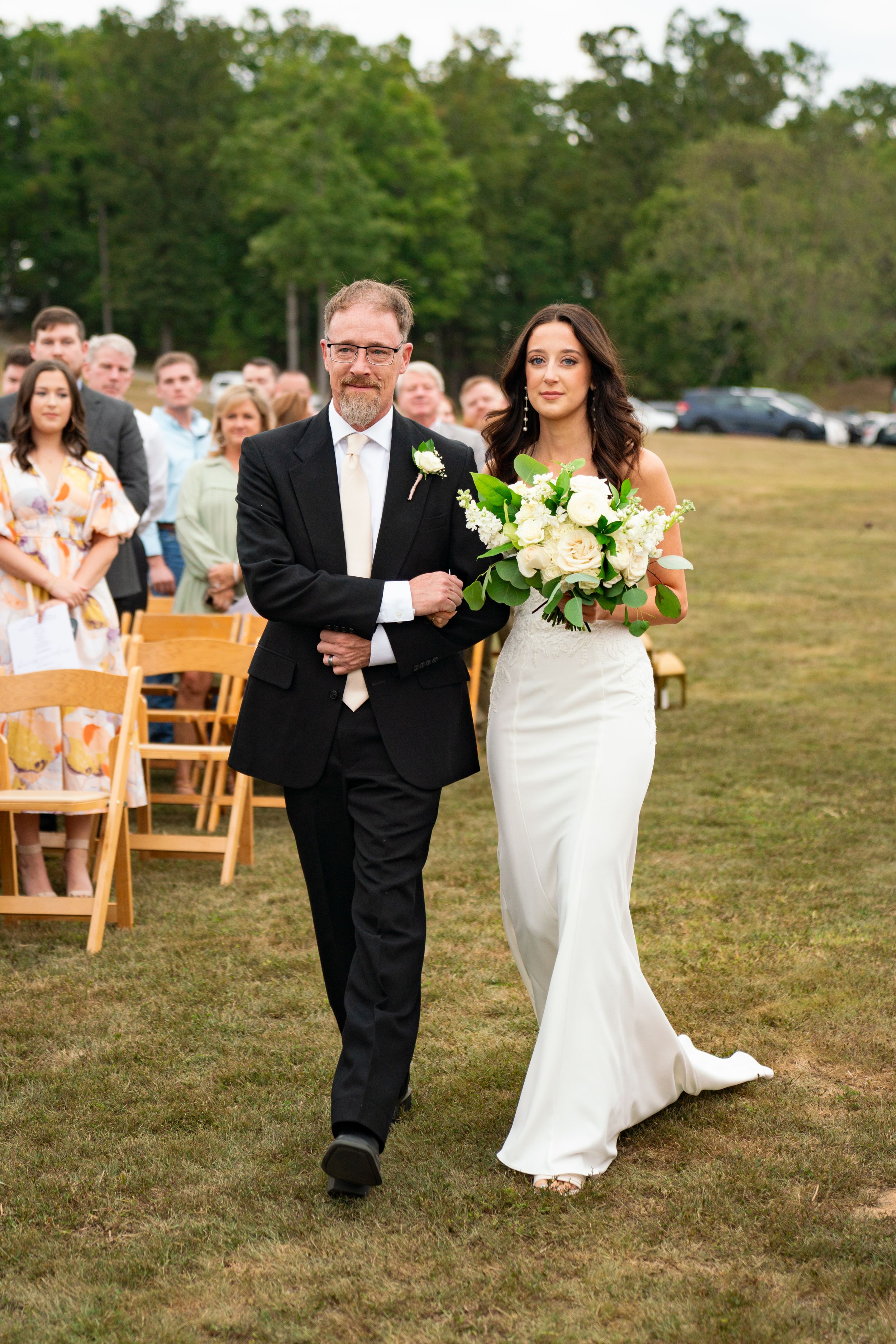 A couple walks down the aisle after their outdoor wedding ceremony.