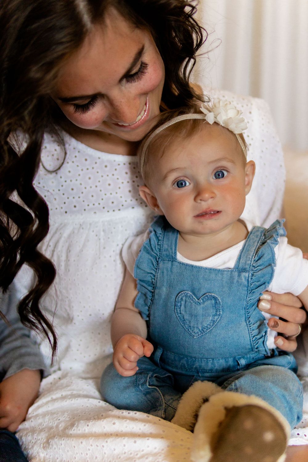 Baby in denim overalls during indoor portrait session.