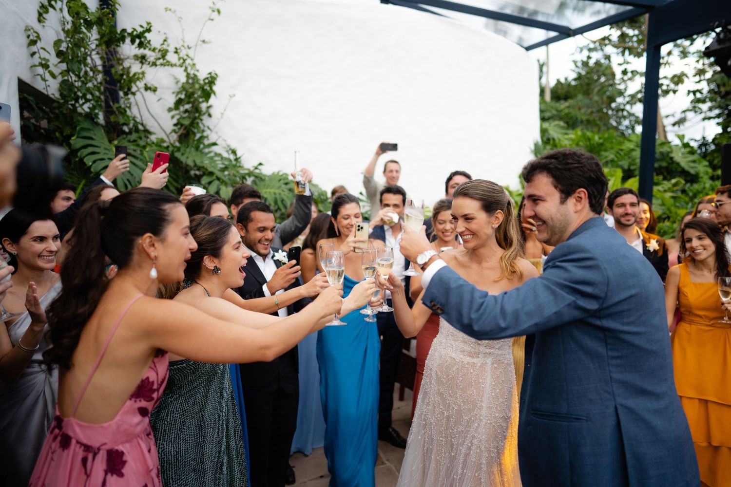 Wedding party celebrates with joyful dancing during outdoor reception.